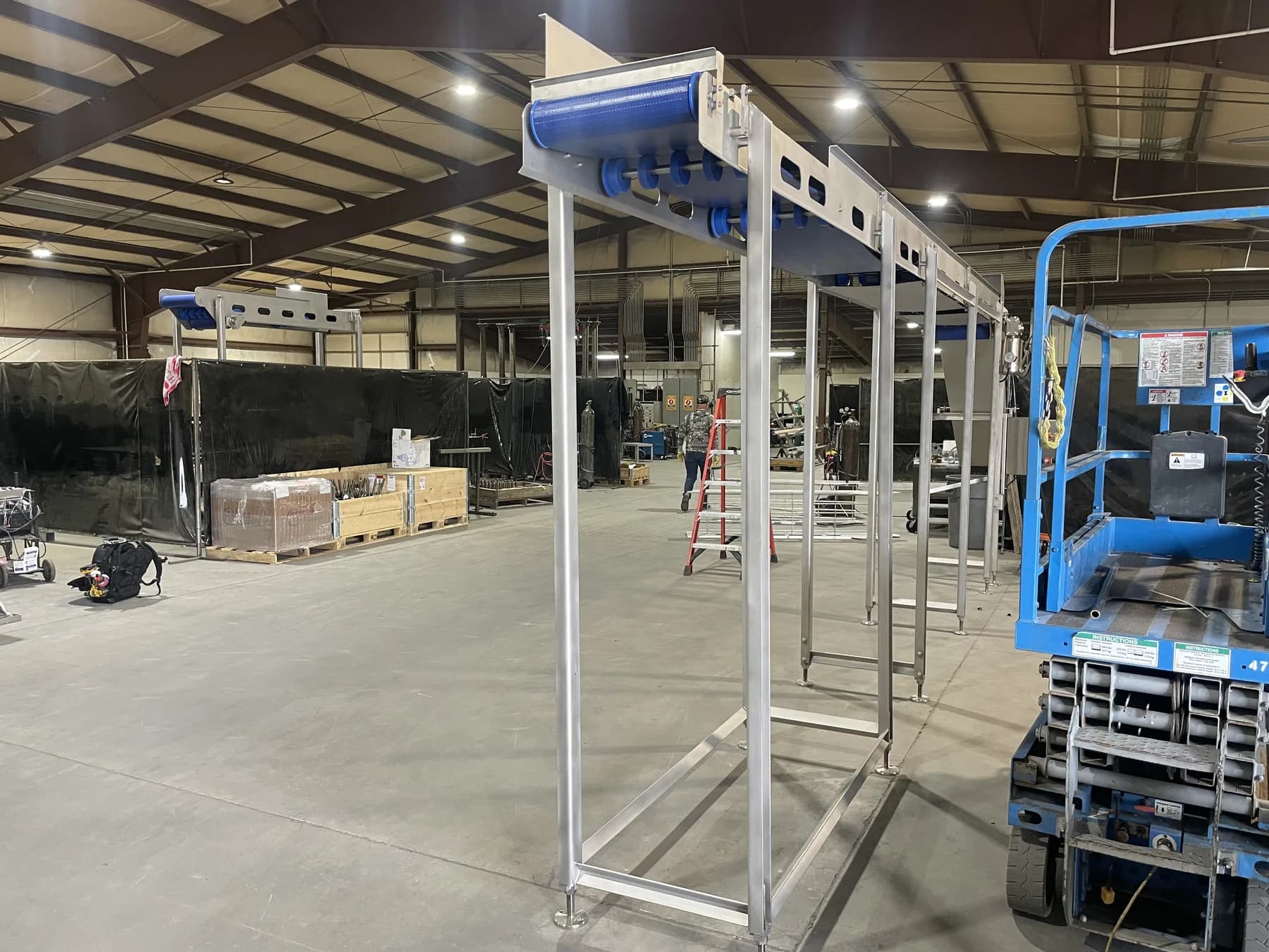 End view of elevated conveyor belt and stainless support frame