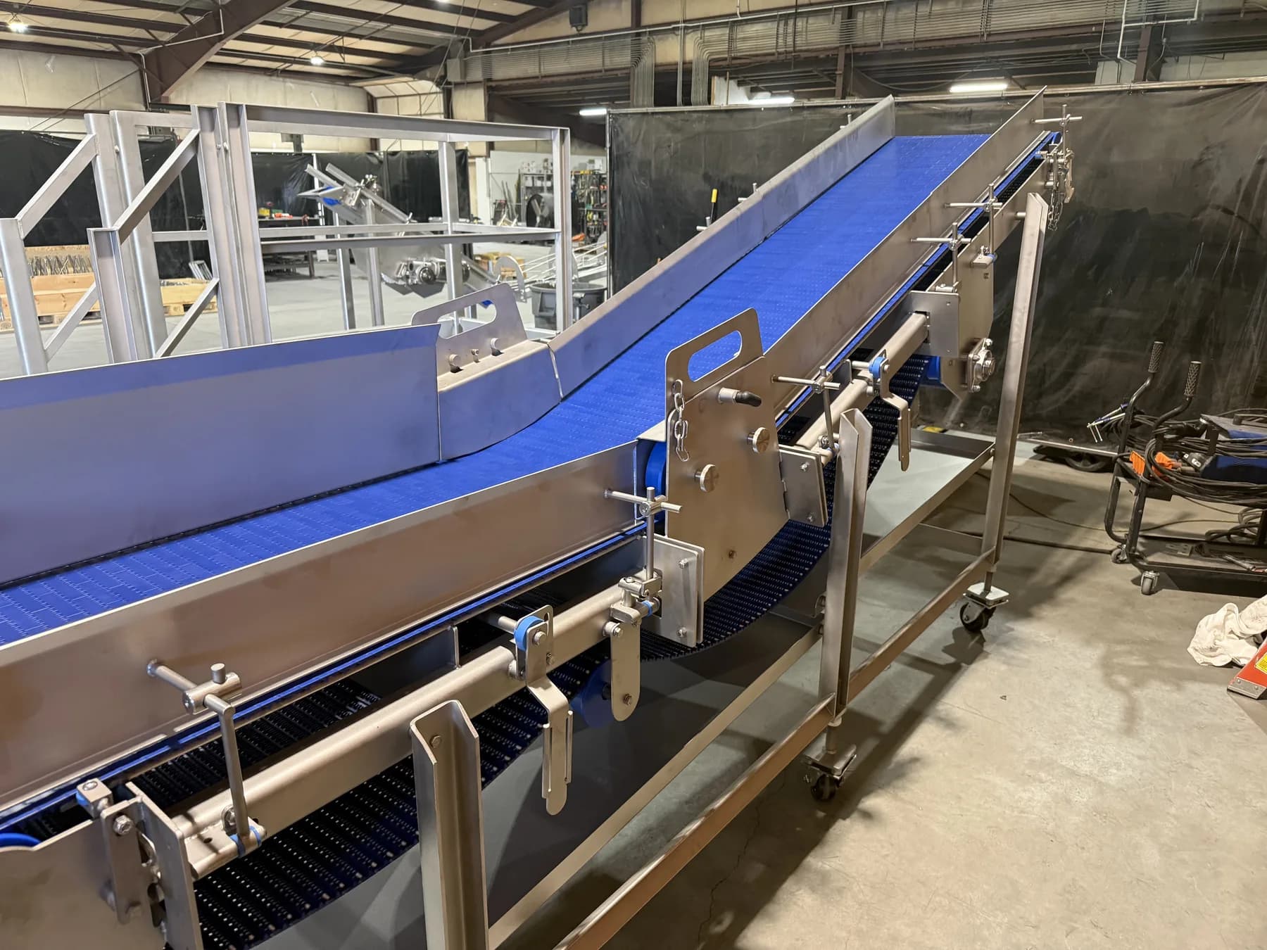 Stainless incline transfer conveyor with blue modular belt and adjustable guide hardware