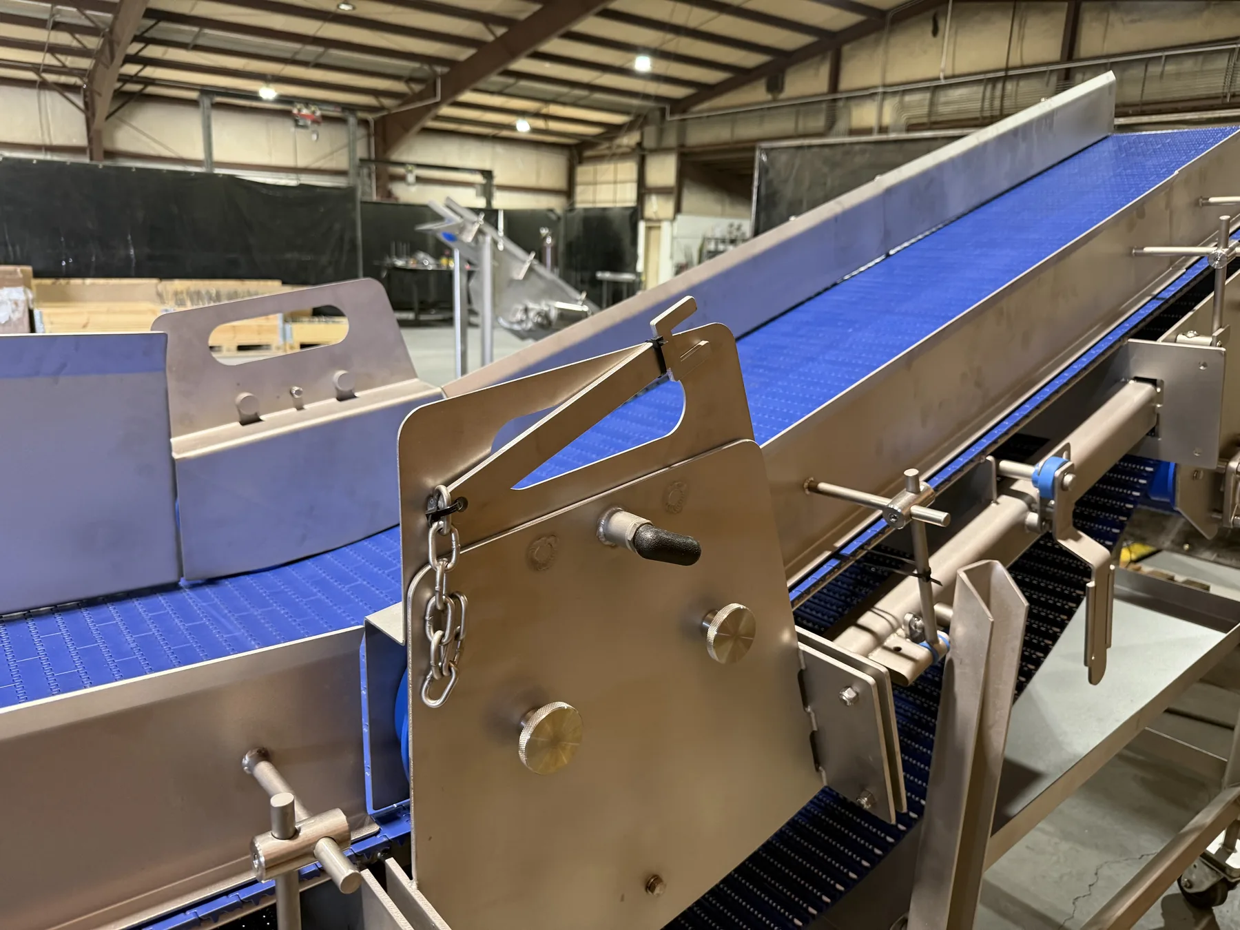 Detail view of adjustable conveyor side plates and guide hardware