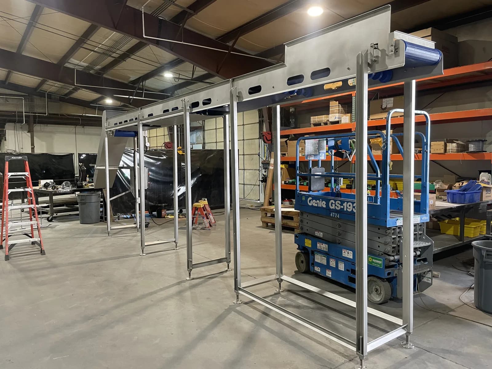 Elevated stainless conveyor system supported above the shop floor