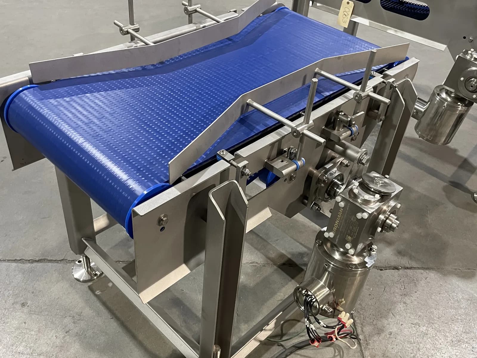 Guided stainless belt conveyor with adjustable rails and pneumatic components